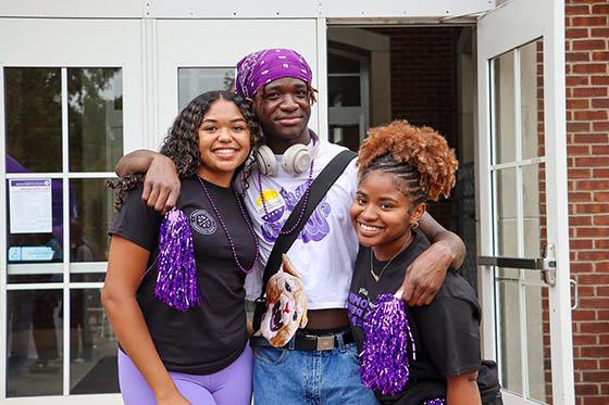 Photo of two Chatham University students walking on Shadyside Campus, with two other students seated nearby on a bench